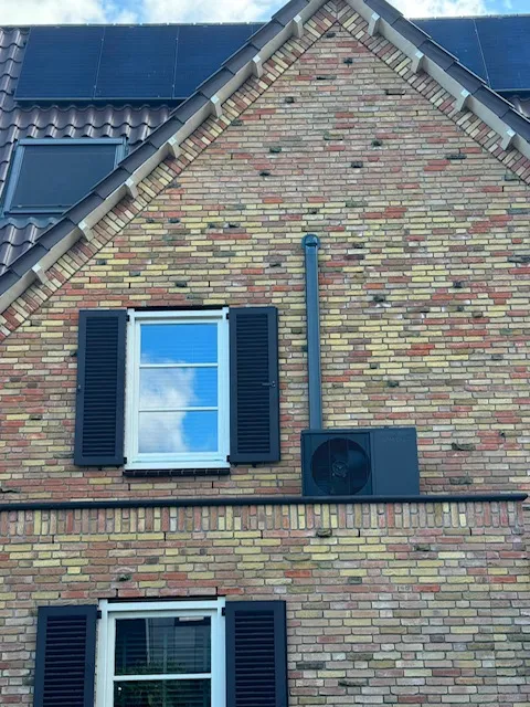 Gerealiseerde Weheat Flint hybride-warmtepomp door HanVos — buitenunit gemonteerd op de gevel/uitbouw